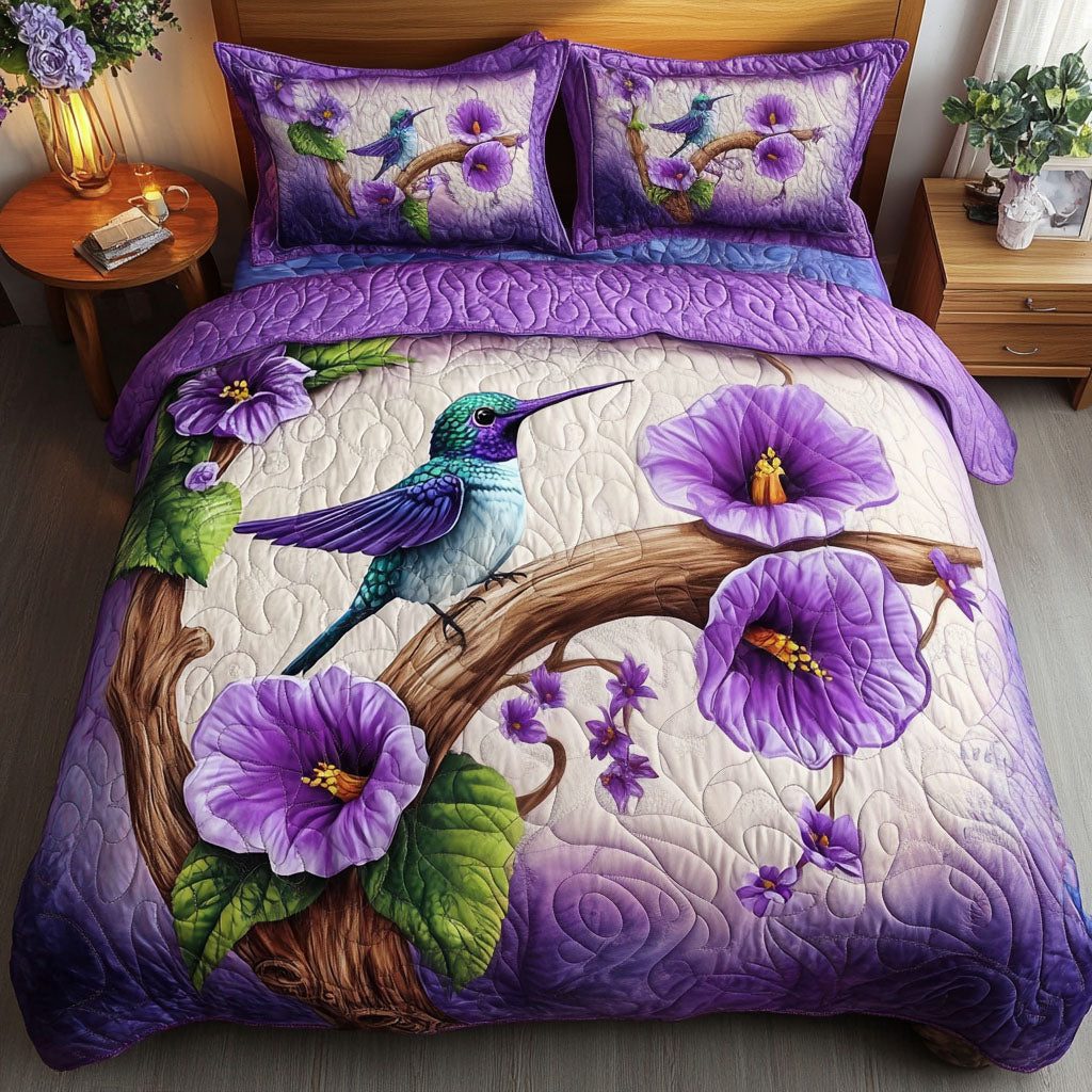 Blooming Hummingbird quilted 3-piece bedding set on a made bed with two matching pillow shams