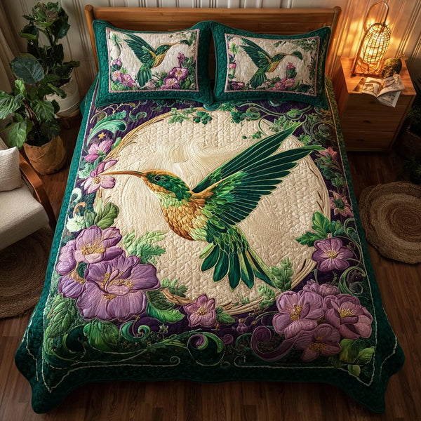 Hummingbird Charm quilted 3-piece bedding set on a made bed with two matching pillow shams