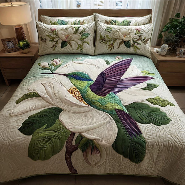 Hummingbird Delight quilted 3-piece bedding set on a made bed with two matching pillow shams