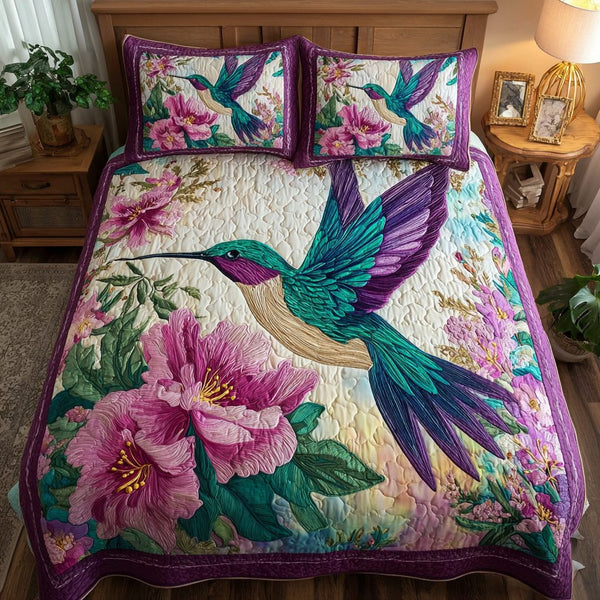 Hummingbird Garden quilted 3-piece bedding set on a made bed with two matching pillow shams