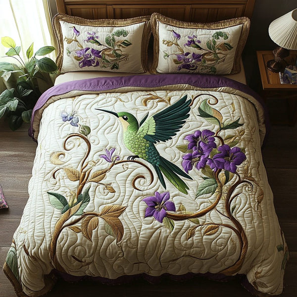 Hummingbird Garden quilted 3-piece bedding set on a made bed with two matching pillow shams