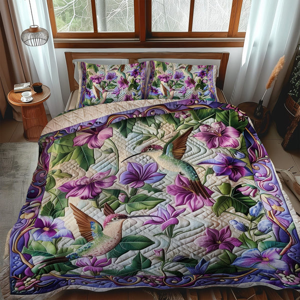 Hummingbird Paradise quilted 3-piece bedding set on a made bed with two matching pillow shams