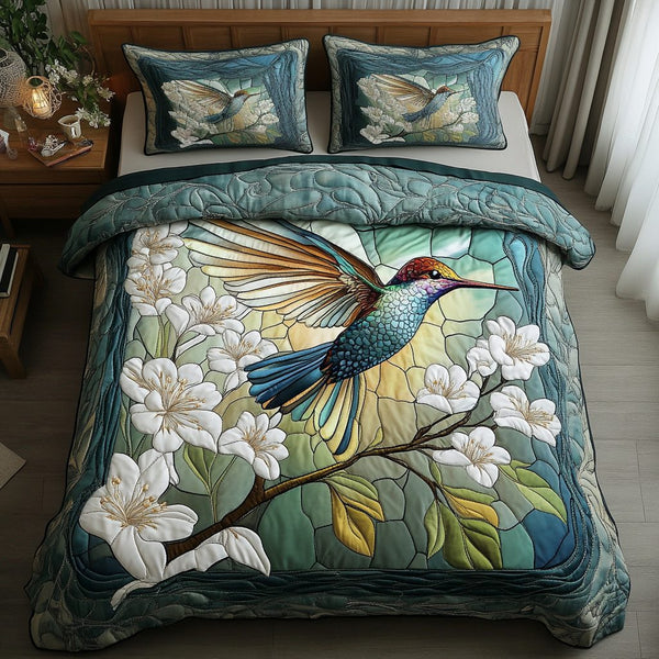 Hummingbird Wings quilted 3-piece bedding set on a made bed with two matching pillow shams