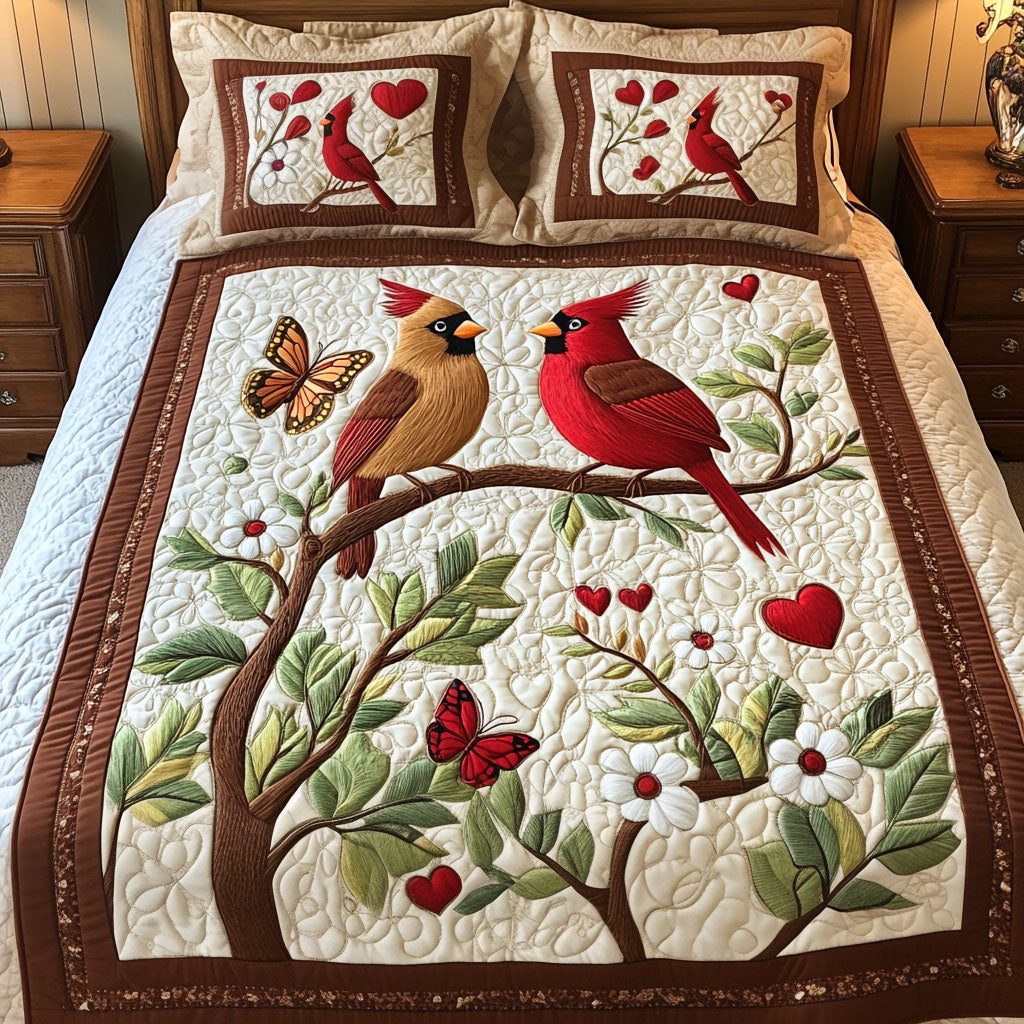 Love Birds quilted 3-piece bedding set on a made bed with two matching pillow shams