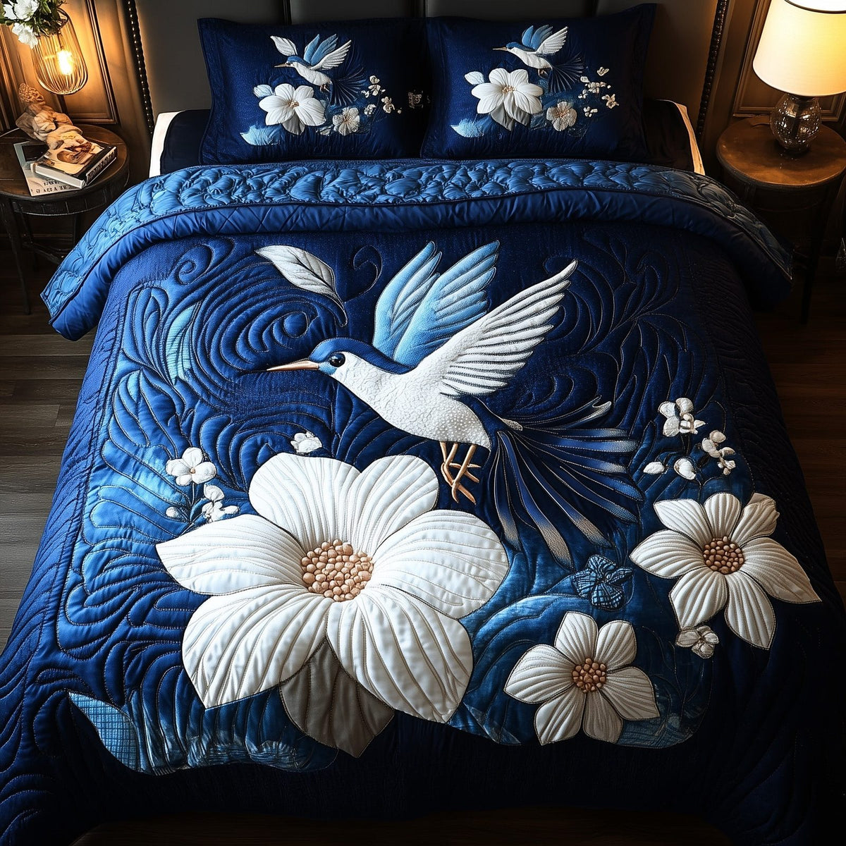 Midnight Bloom Hummingbird quilted 3-piece bedding set on a made bed with two matching pillow shams