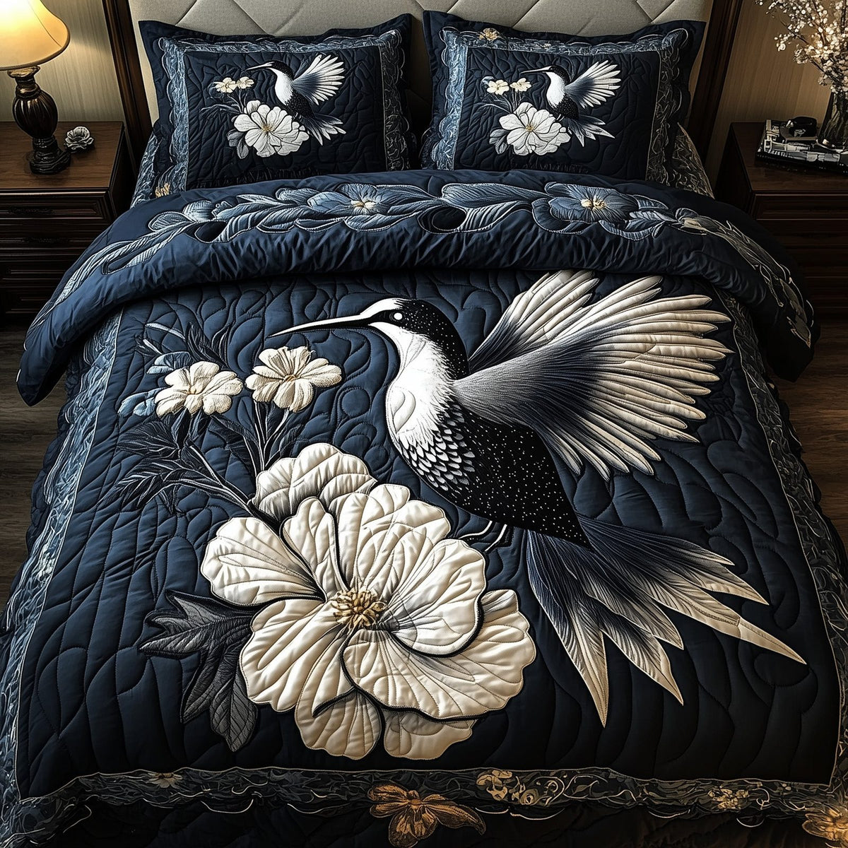 Monochrome Hummingbird quilted 3-piece bedding set on a made bed with two matching pillow shams