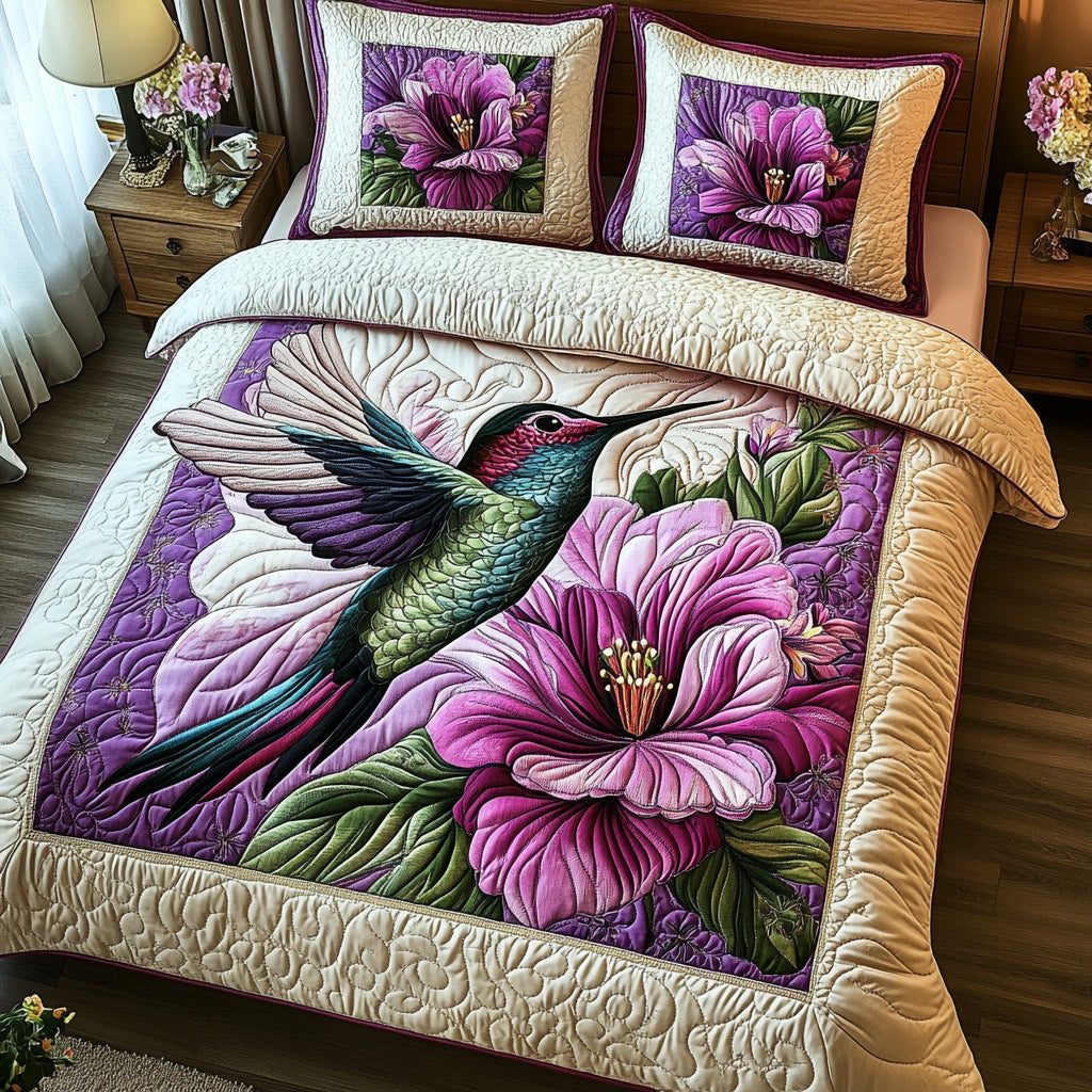 Purple Hummingbird quilted 3-piece bedding set on a made bed with two matching pillow shams