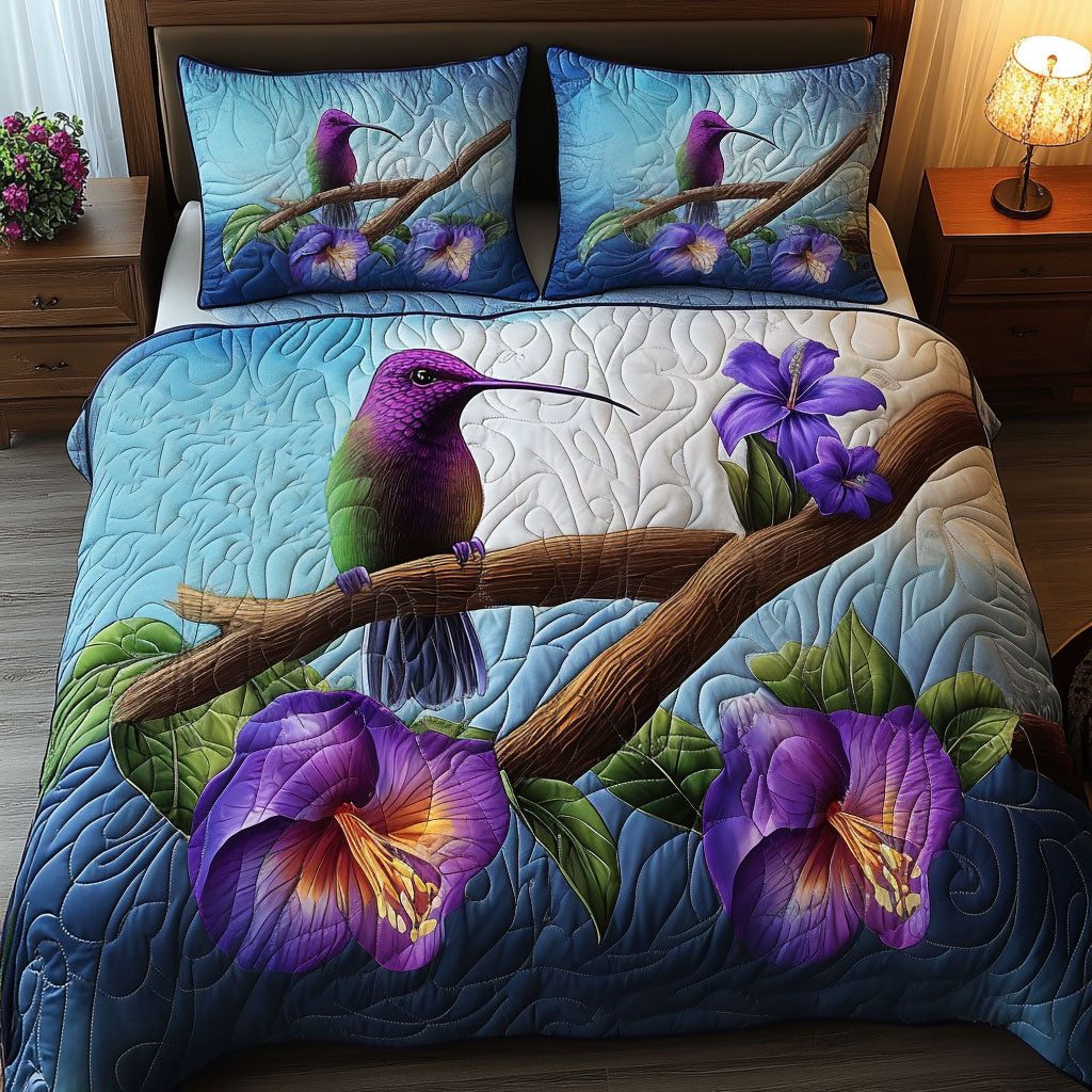 Purple Hummingbird quilted 3-piece bedding set on a made bed with two matching pillow shams