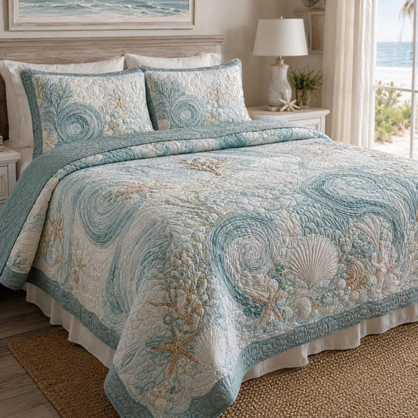 Seashell Serenity quilted 3-piece bedding set on a made bed in a light coastal bedroom