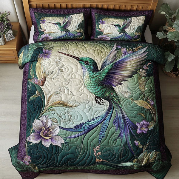 Vibrant Hummingbird quilted 3-piece bedding set on a made bed with two matching pillow shams