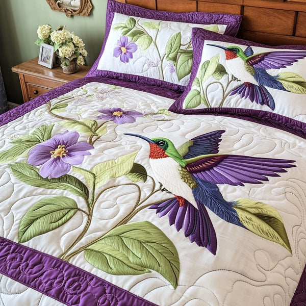 Vibrant Hummingbird quilted 3-piece bedding set on a made bed with two matching pillow shams