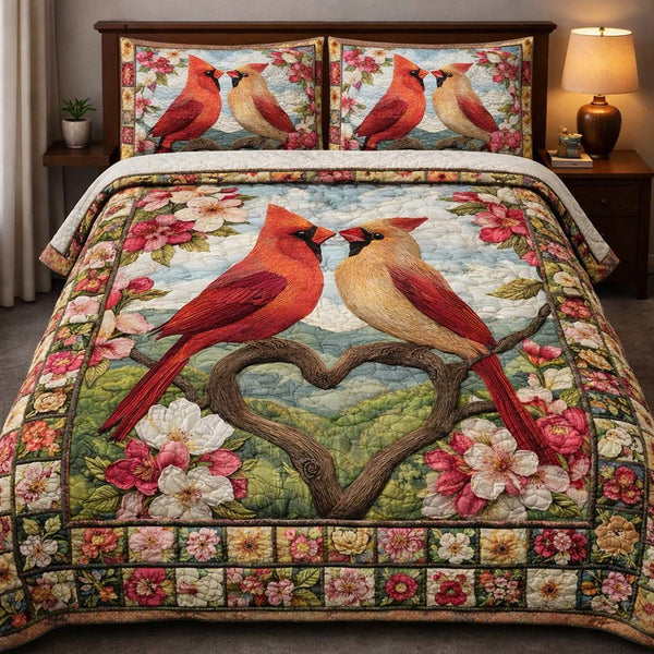 Blushing Cardinal Love quilted 3-piece bedding set on a made bed with two matching pillow shams
