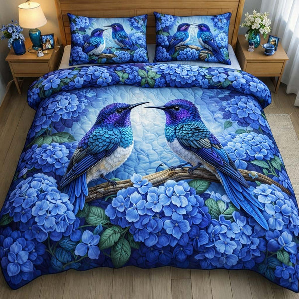Blue Hydrangea Hummingbirds quilted 3-piece bedding set on a made bed with two matching pillow shams
