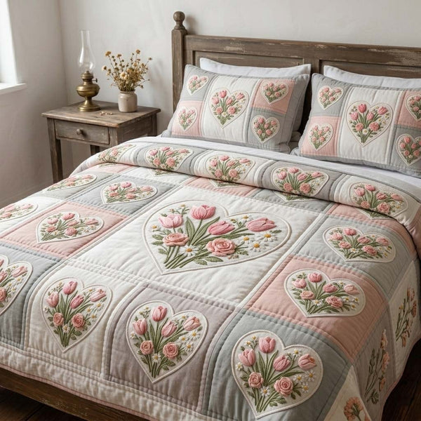 Blush Tulip Garden quilted 3-piece bedding set on a made bed with two matching pillow shams