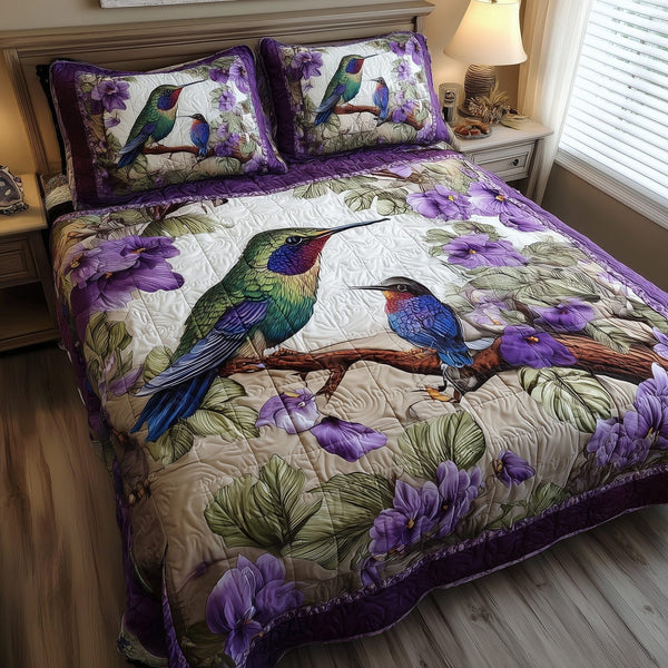 Amethyst Hummingbird Love quilted 3-piece bedding set on a made bed with two matching pillow shams