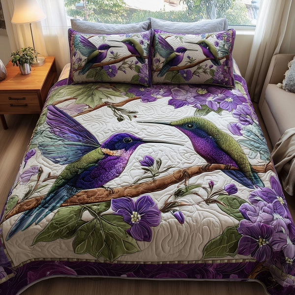 Amethyst Hummingbird Love quilted 3-piece bedding set on a made bed with two matching pillow shams