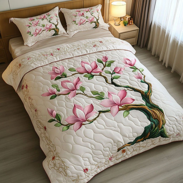 Blooming Magnolia Bliss quilted 3-piece bedding set on a made bed with two matching pillow shams