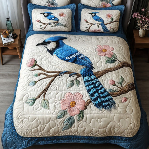 Blue Feather Delight quilted 3-piece bedding set on a made bed with two matching pillow shams