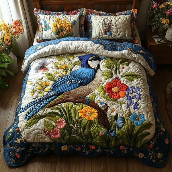 Blue Jay Bloom quilted 3-piece bedding set on a made bed with two matching pillow shams