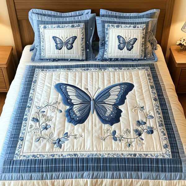 Blue Wings quilted 3-piece bedding set on a made bed with two matching pillow shams