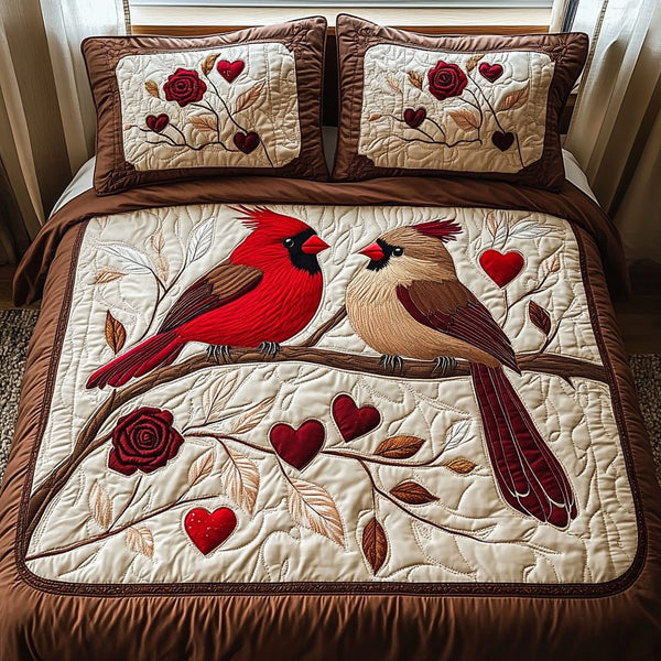 Cardinal Romance quilted 3-piece bedding set on a made bed with two matching pillow shams