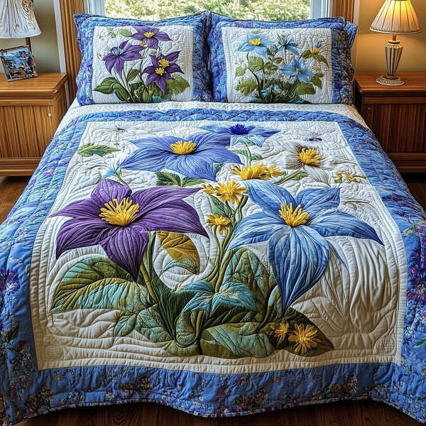 Columbine Charm quilted 3-piece bedding set on a made bed with two matching pillow shams