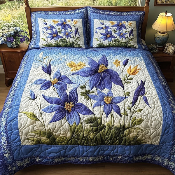 Columbine Charm quilted 3-piece bedding set on a made bed with two matching pillow shams