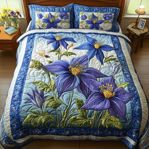 Columbine Charm quilted 3-piece bedding set on a made bed with two matching pillow shams