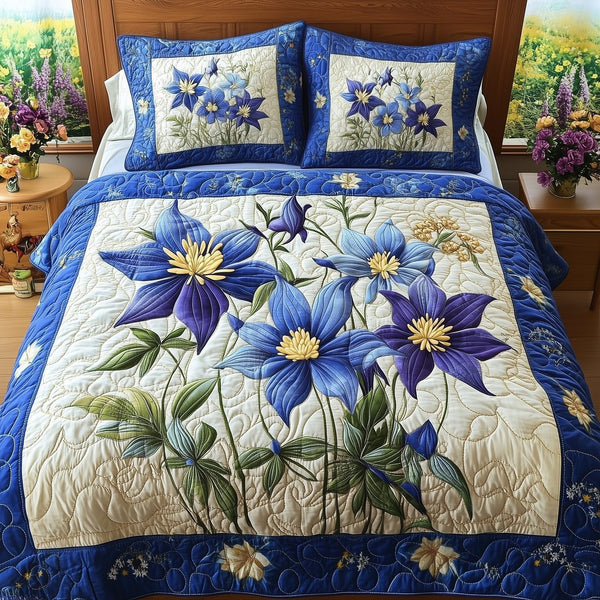 Columbine Charm quilted 3-piece bedding set on a made bed with two matching pillow shams