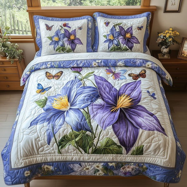 Columbine Charm quilted 3-piece bedding set on a made bed with two matching pillow shams