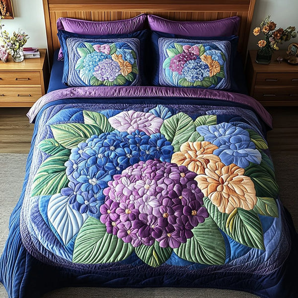 Cozy Hydrangea quilted 3-piece bedding set on a made bed with two matching pillow shams
