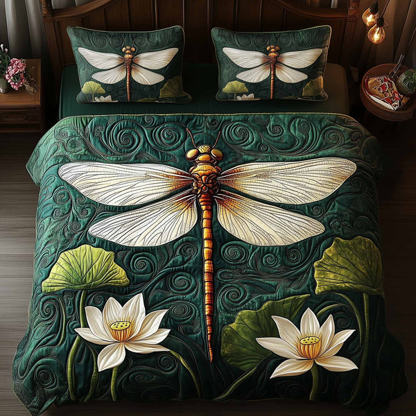 Dragonfly Glow quilted 3-piece bedding set on a made bed with two matching pillow shams