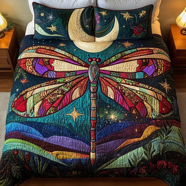 Dragonfly Glow quilted 3-piece bedding set on a made bed with two matching pillow shams