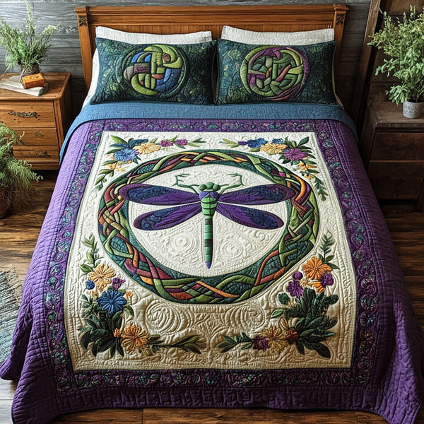 Dragonfly Legacy quilted 3-piece bedding set on a made bed with two matching pillow shams