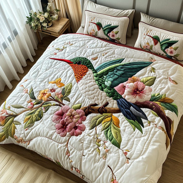Elegant Hummingbird quilted 3-piece bedding set on a made bed with two matching pillow shams