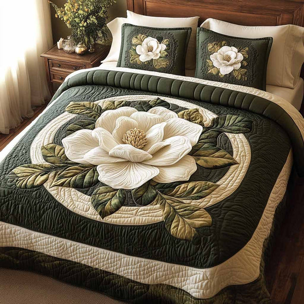 Emerald Magnolia quilted 3-piece bedding set on a made bed with two matching pillow shams