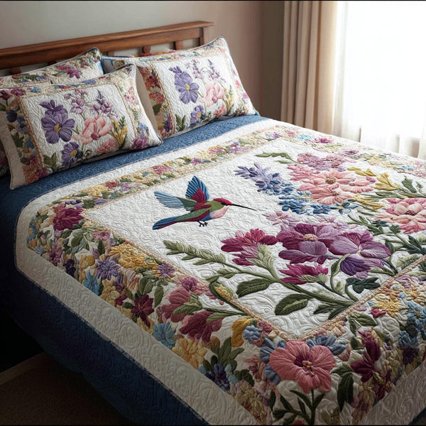 Floral Hummingbird quilted 3-piece bedding set on a made bed with two matching pillow shams