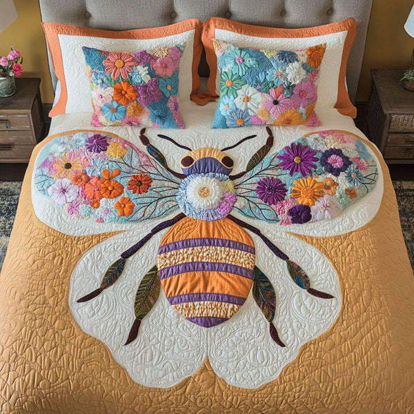 Floral Wings Bee quilted 3-piece bedding set on a made bed with two matching pillow shams