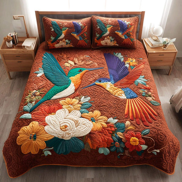 Golden Garden Hummers quilted 3-piece bedding set on a made bed with two matching pillow shams