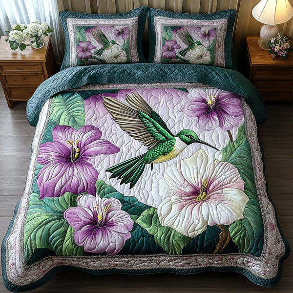 Graceful Hummingbird quilted 3-piece bedding set on a made bed with two matching pillow shams