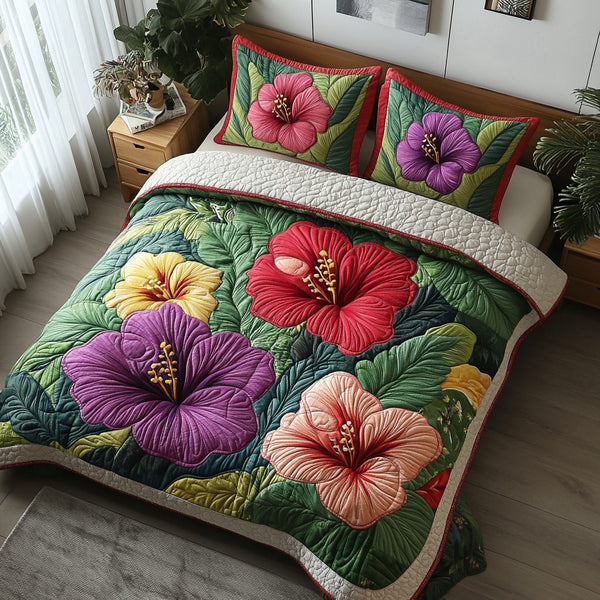 Hibiscus Bloom quilted 3-piece bedding set on a made bed with two matching pillow shams