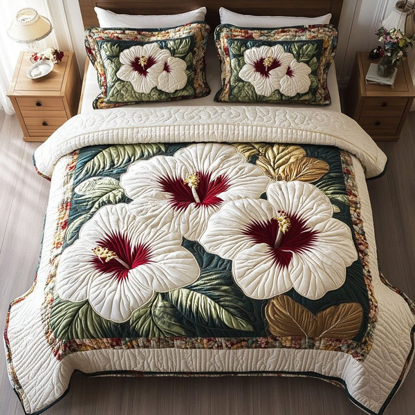 Hibiscus Bloom quilted 3-piece bedding set on a made bed with two matching pillow shams