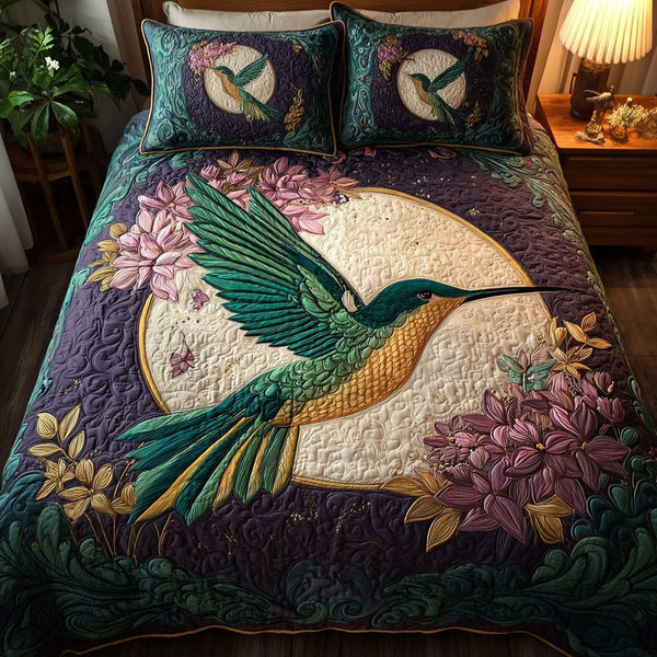 Hummingbird Beauty quilted 3-piece bedding set on a made bed with two matching pillow shams