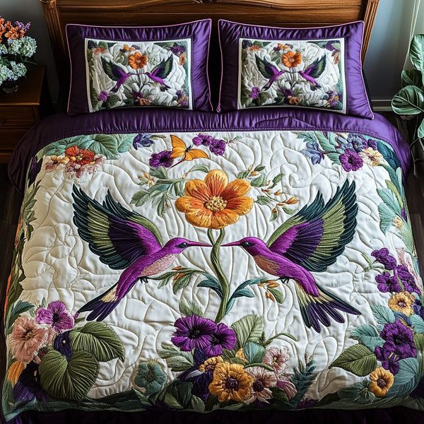 Hummingbird Bliss quilted 3-piece bedding set on a made bed with two matching pillow shams