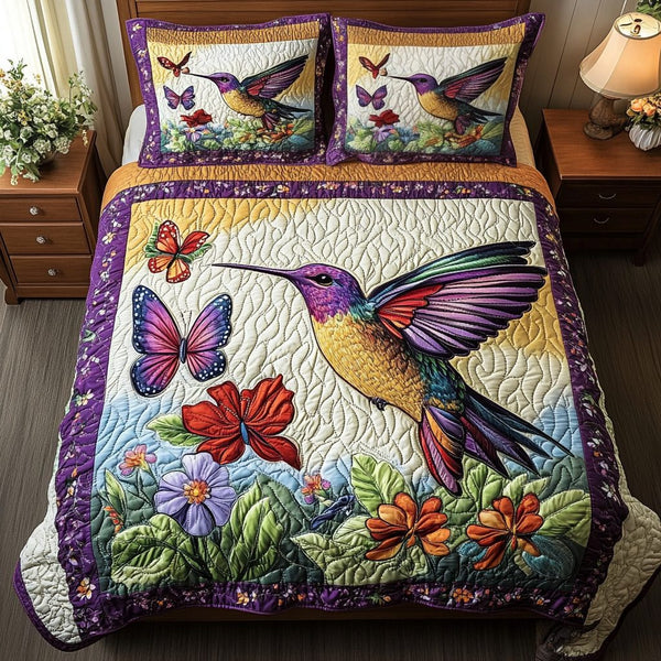 Hummingbird Bloom quilted 3-piece bedding set on a made bed with two matching pillow shams