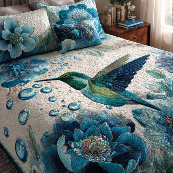 Hummingbird Bloom quilted 3-piece bedding set on a made bed with two matching pillow shams