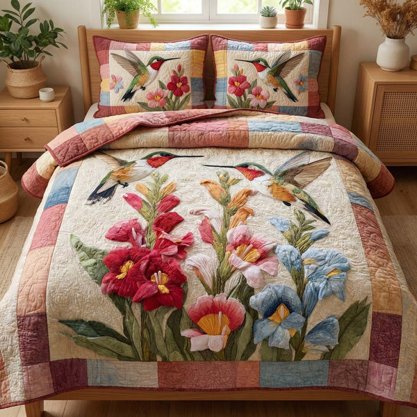 Hummingbird Blooms quilted 3-piece bedding set on a made bed with two matching pillow shams