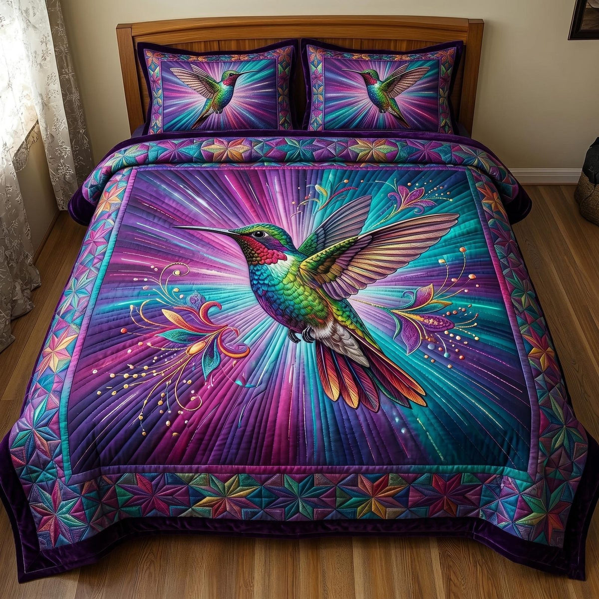 Hummingbird Blossom quilted 3-piece bedding set on a made bed with two matching pillow shams