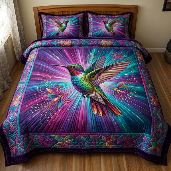 Hummingbird Blossom quilted 3-piece bedding set on a made bed with two matching pillow shams
