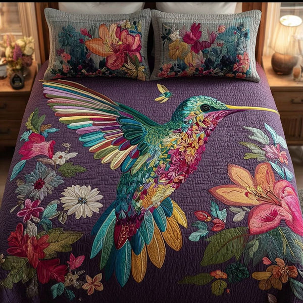 Hummingbird Charm quilted 3-piece bedding set on a made bed with two matching pillow shams